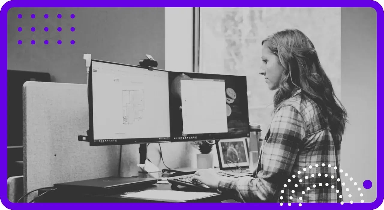 A professional working at a dual-monitor workstation supported by managed IT services