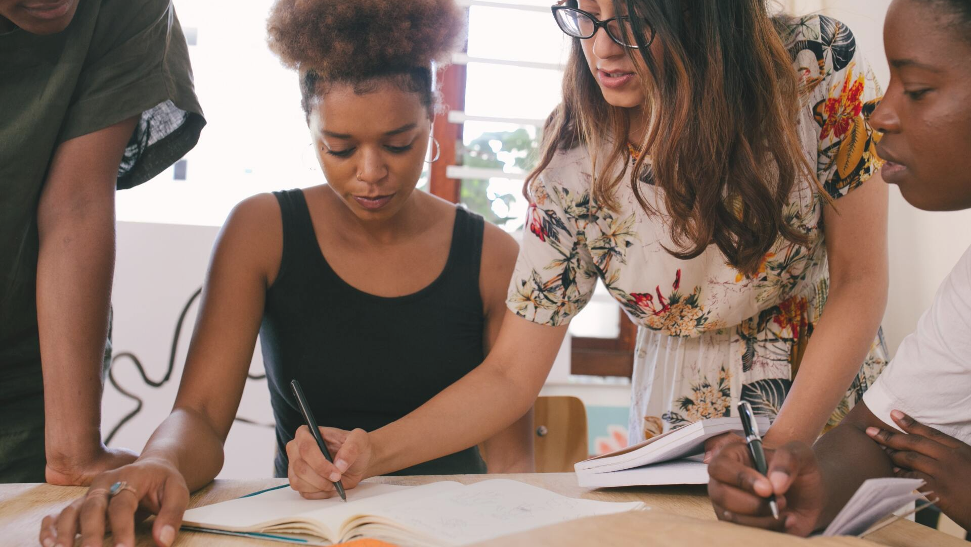 People writing in notebook