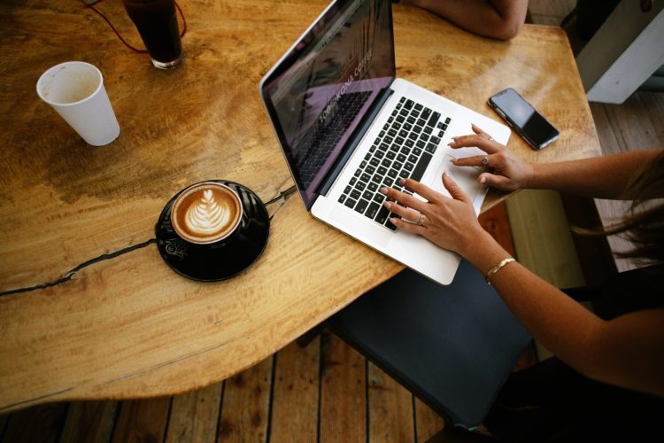 a person using their laptop at a cafe on public wifi